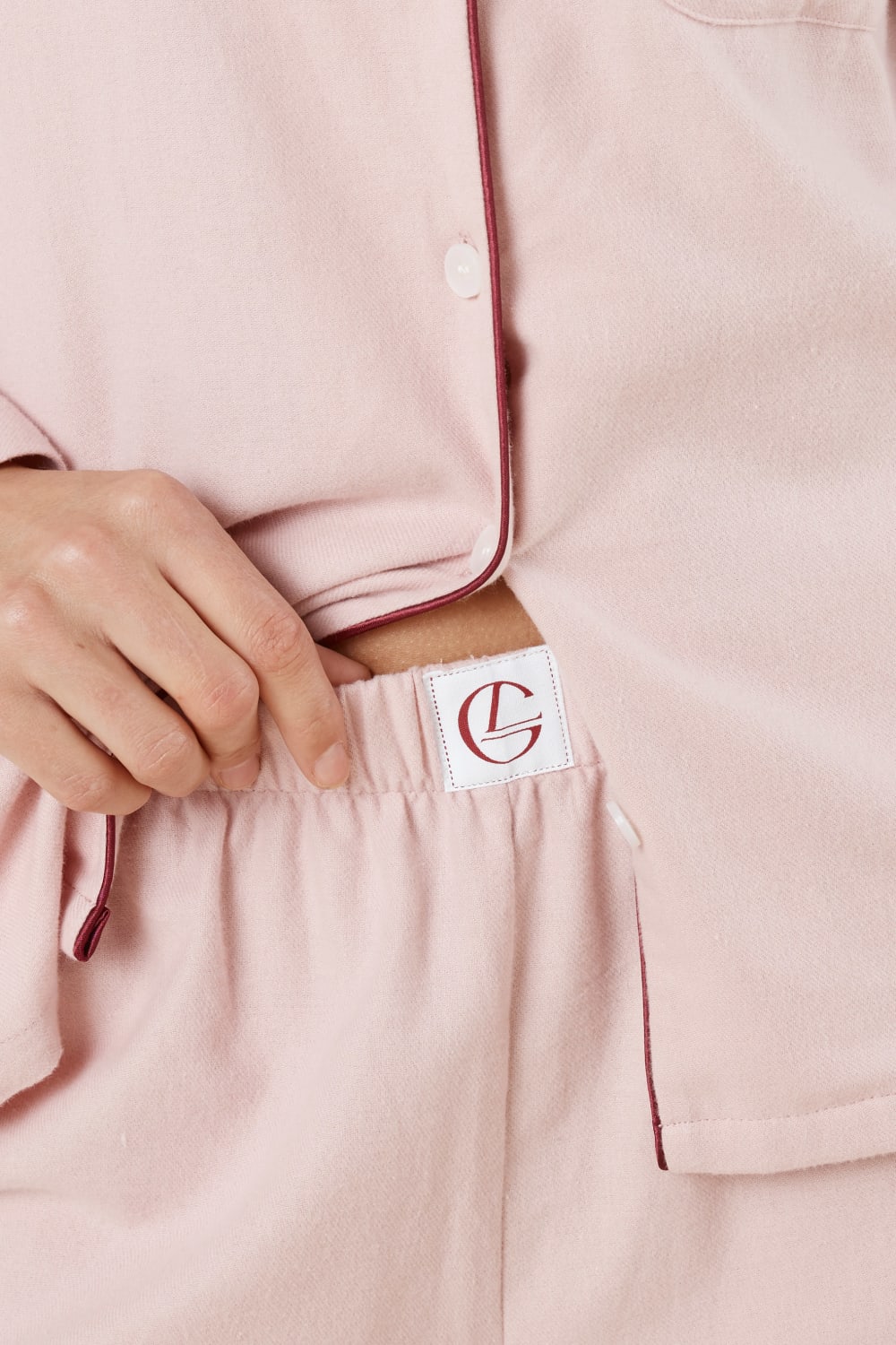 Close up view of waist of pink isabella brushed cotton pyjama PJ set pants with a small Gingerlilly logo and contrast piping.