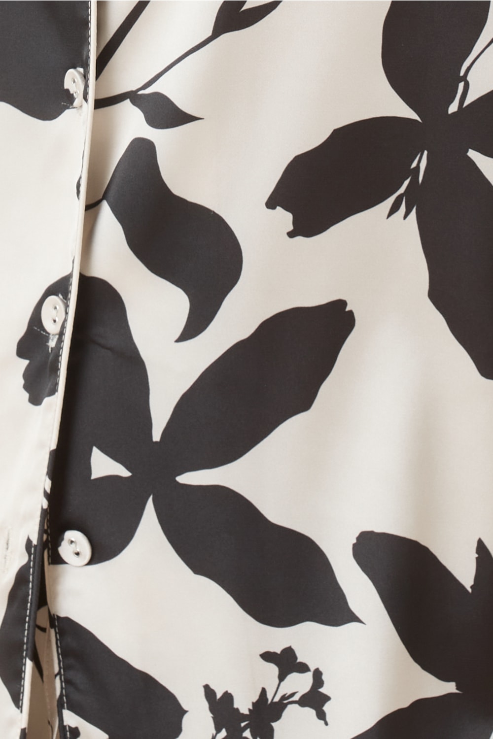Close-up of the Ivy Silky Satin pyjama PJ set with black floral pattern and white buttons