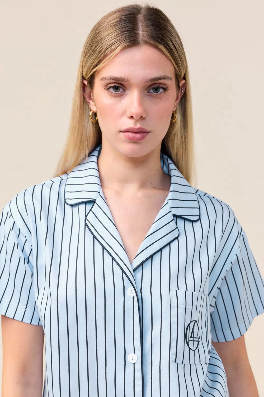 Woman wearing the Lisa Stripe Long Pant PJ Set in Blue, close front view of collar and embroidered logo