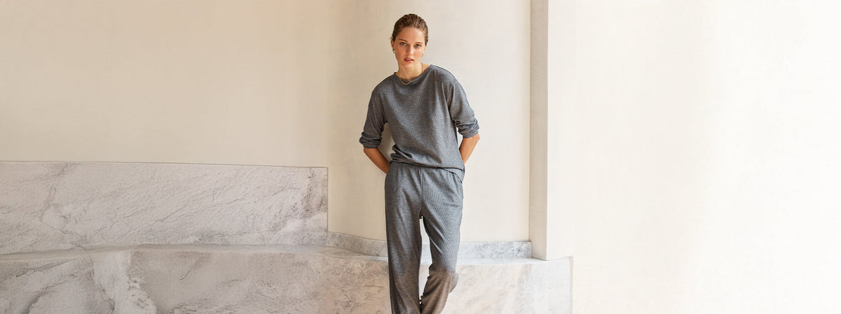 Woman in grey Gingerlilly sleepwear loungewear set, standing in minimalist room