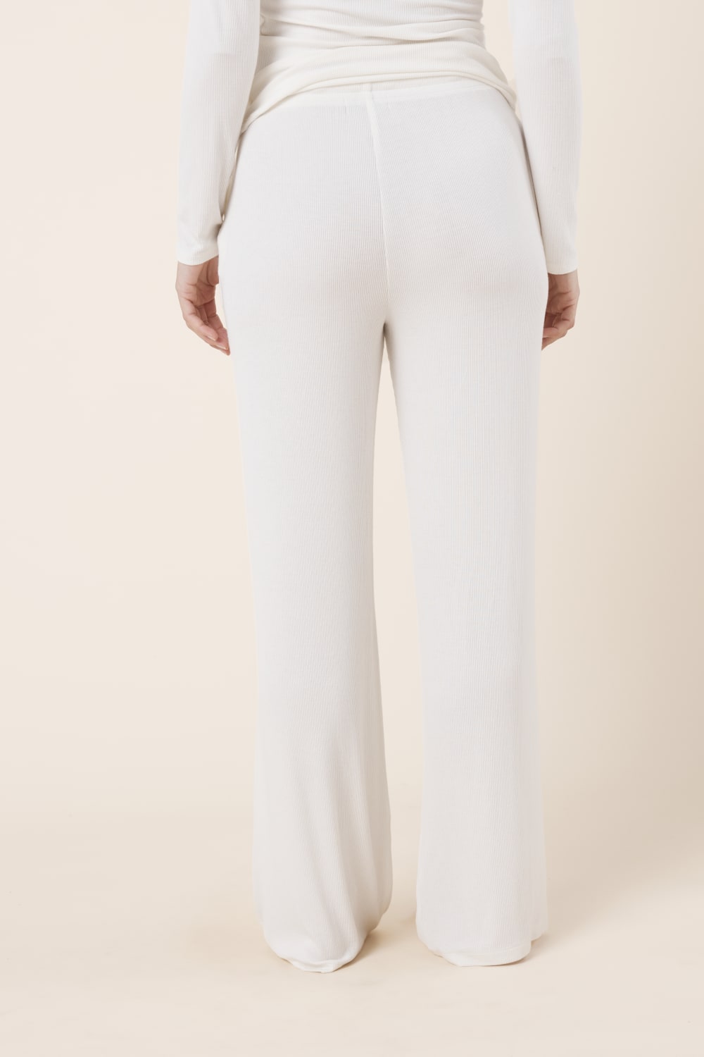 Woman wearing Athens Ribbed Long Pants Ivory, back view of relaxed ribbed wide leg lounge pants