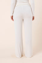 Woman wearing Athens Ribbed Long Pants Ivory, back view of relaxed ribbed wide leg lounge pants