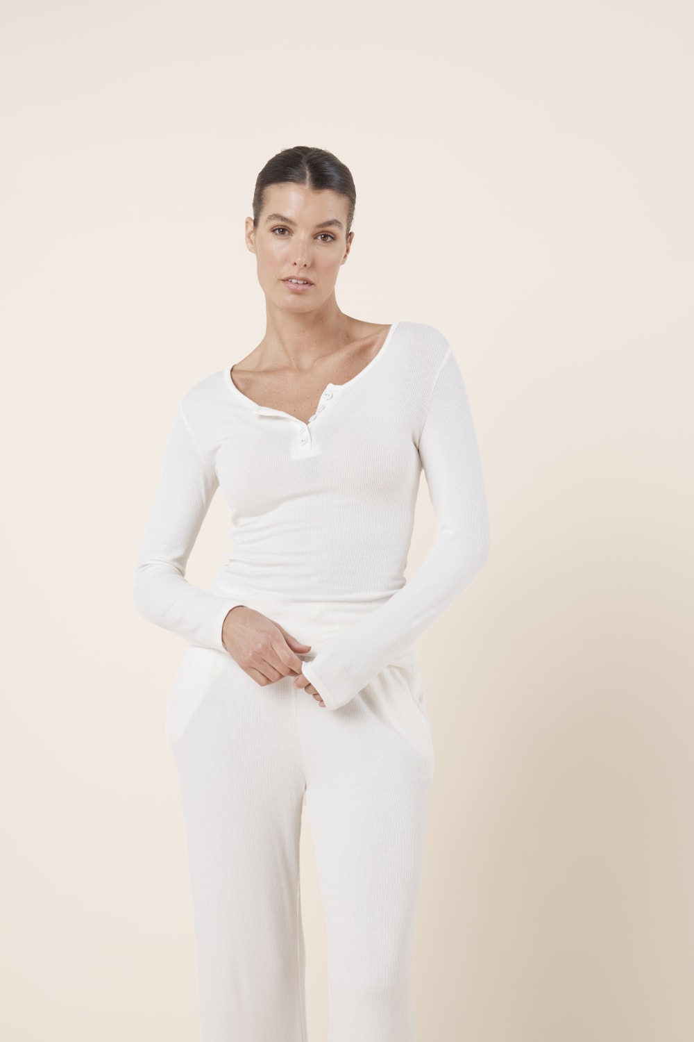 Woman wearing Athens Ribbed Long Pants Ivory with matching ribbed long sleeve lounge top
