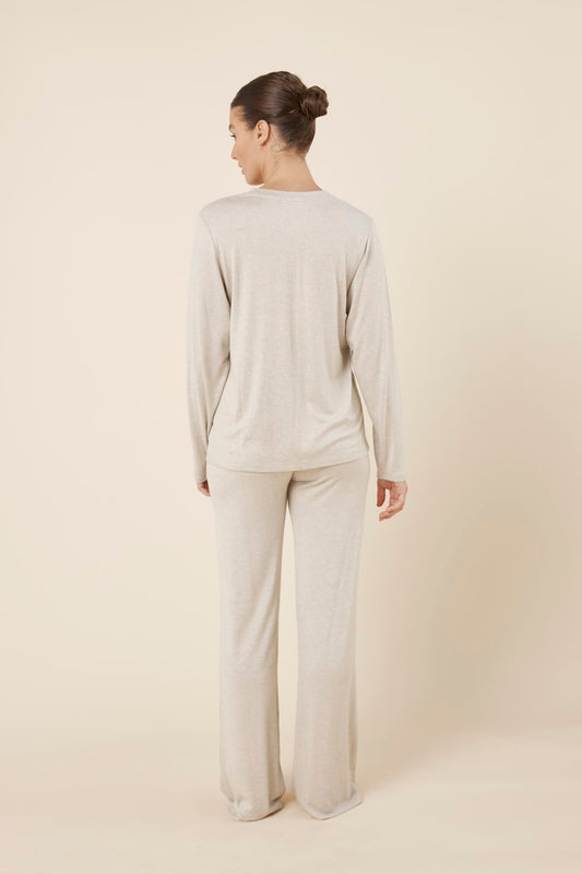 Woman wearing a brianna lounge set oatmeal on a plain beige background back view