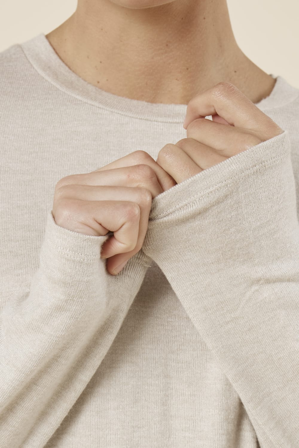 Woman wearing a brianna lounge set oatmeal on a plain beige background close up view of the cuff and neck