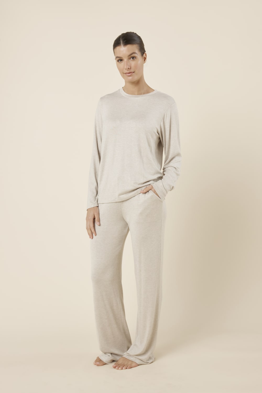 Woman wearing a brianna lounge set oatmeal on a plain beige background side on view
