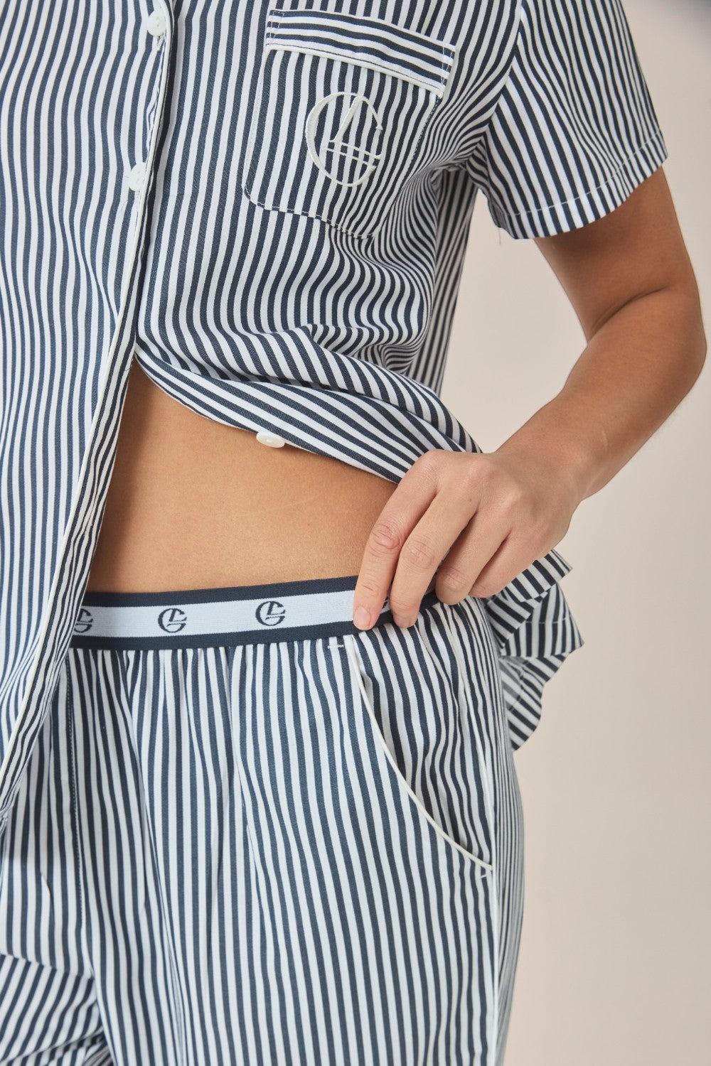 Close-up of a navy and white striped pyjama shirt and pants, showing the branded elastic waistband.