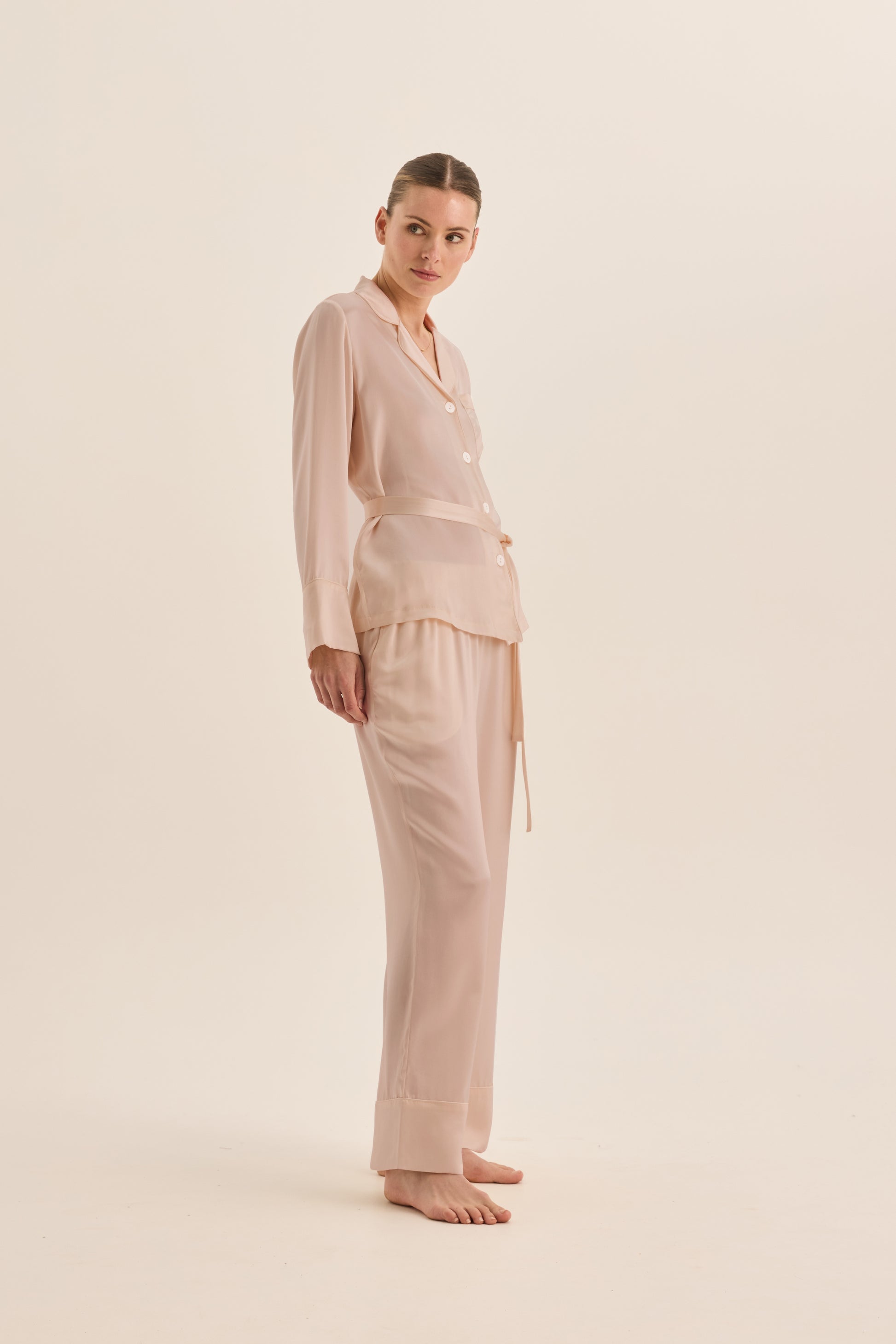 Woman wearing Gingerlilly Sleepwear ivory pajama set made from natural fabric, side view