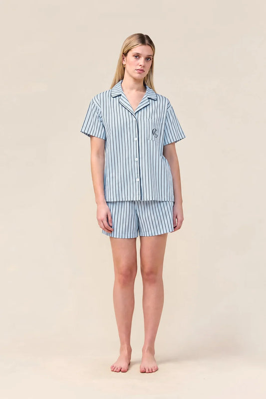 Woman wearing the Poppy Stripe Short PJ Set in Blue, front view of short sleeve shirt and shorts