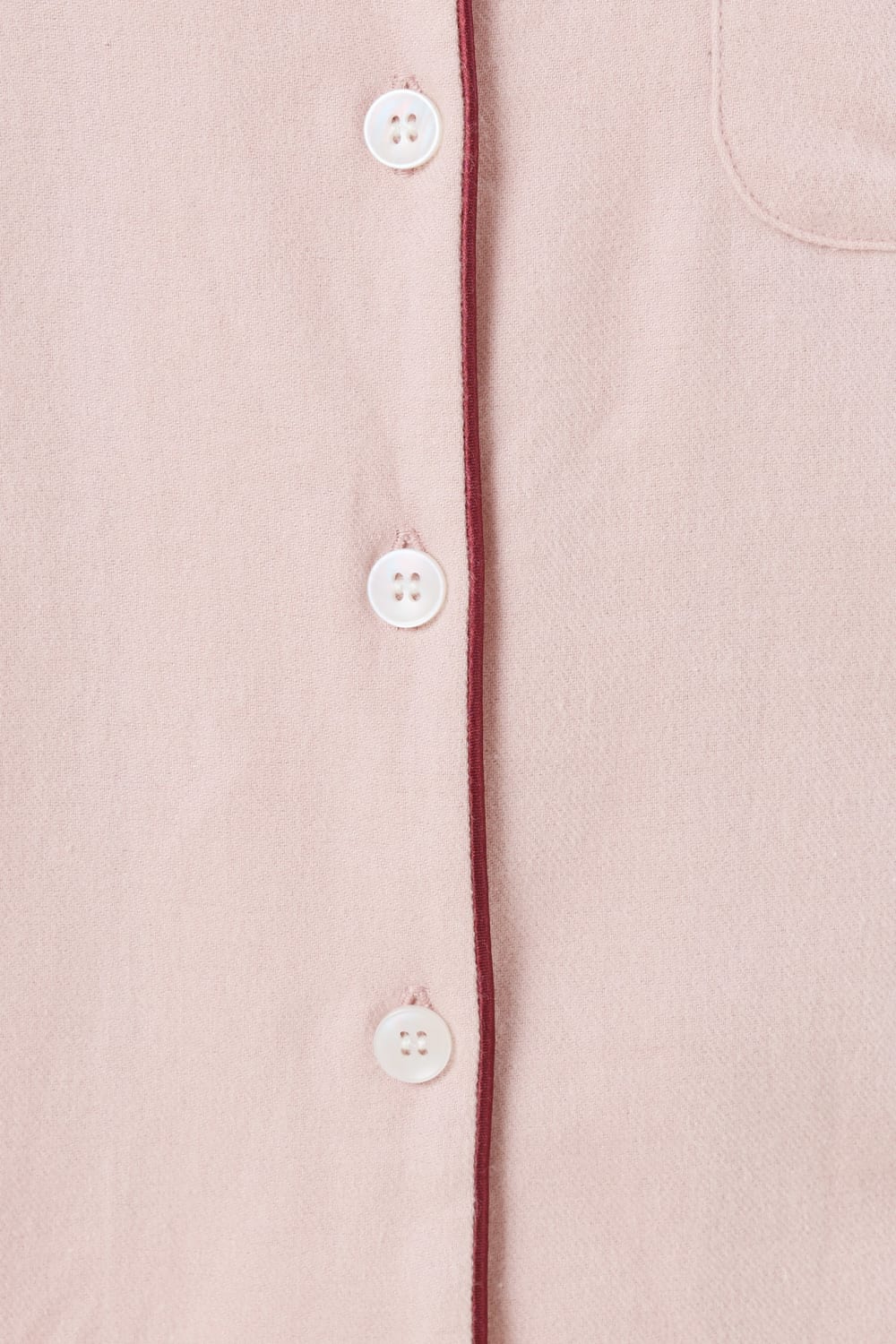 Close up view of pink isabella brushed cotton pyjama PJ set top white buttons and contrast red burgundy piping detail. 