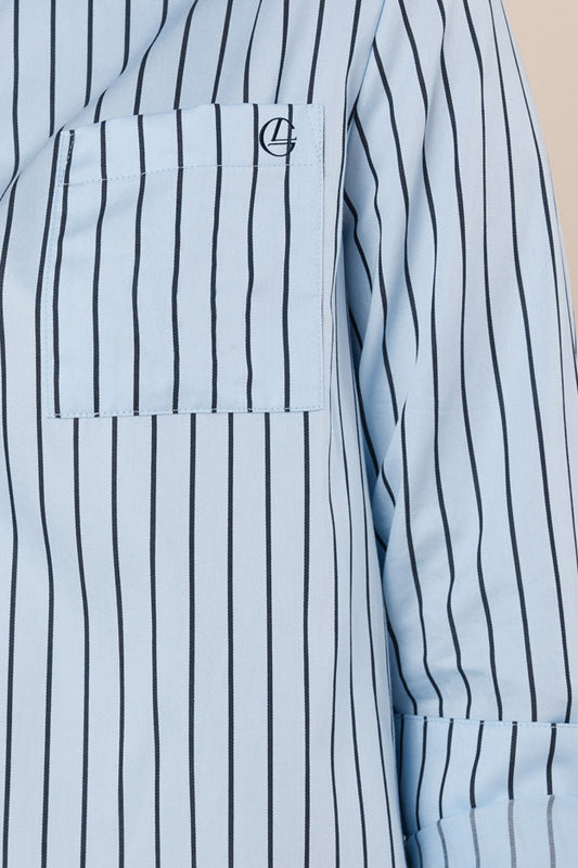 Light blue shirt with black vertical stripes and a logo on the chest pocket.