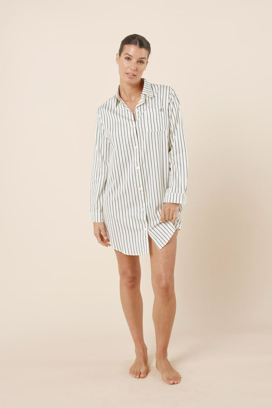 Woman wearing a striped nightshirt on a beige background
