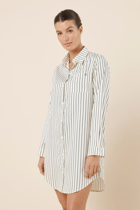 Woman wearing a striped shirt dress on a beige background