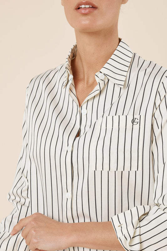 Close-up of a person wearing a striped shirt with a neutral background