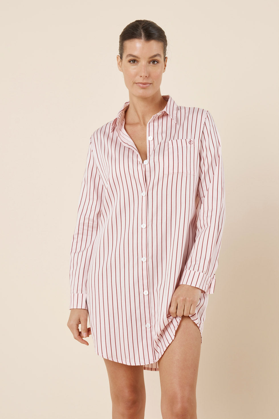 Woman wearing a striped shirt dress against a beige background