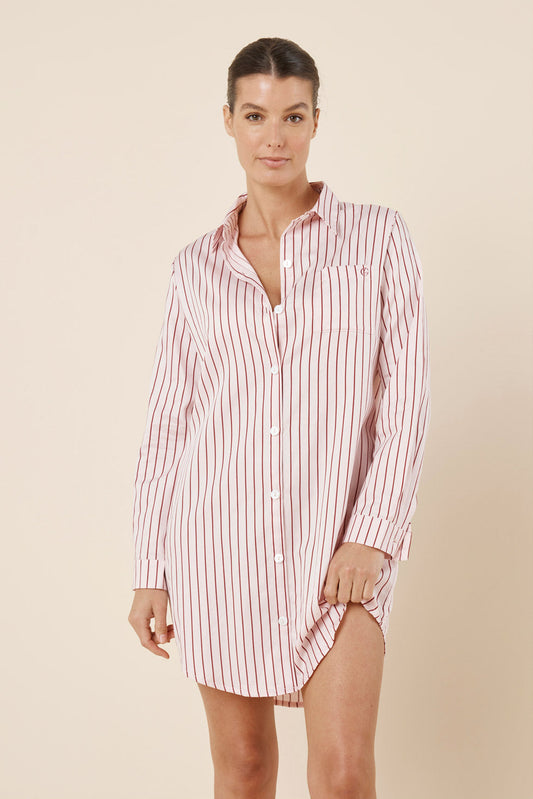Woman wearing a striped shirt dress against a beige background