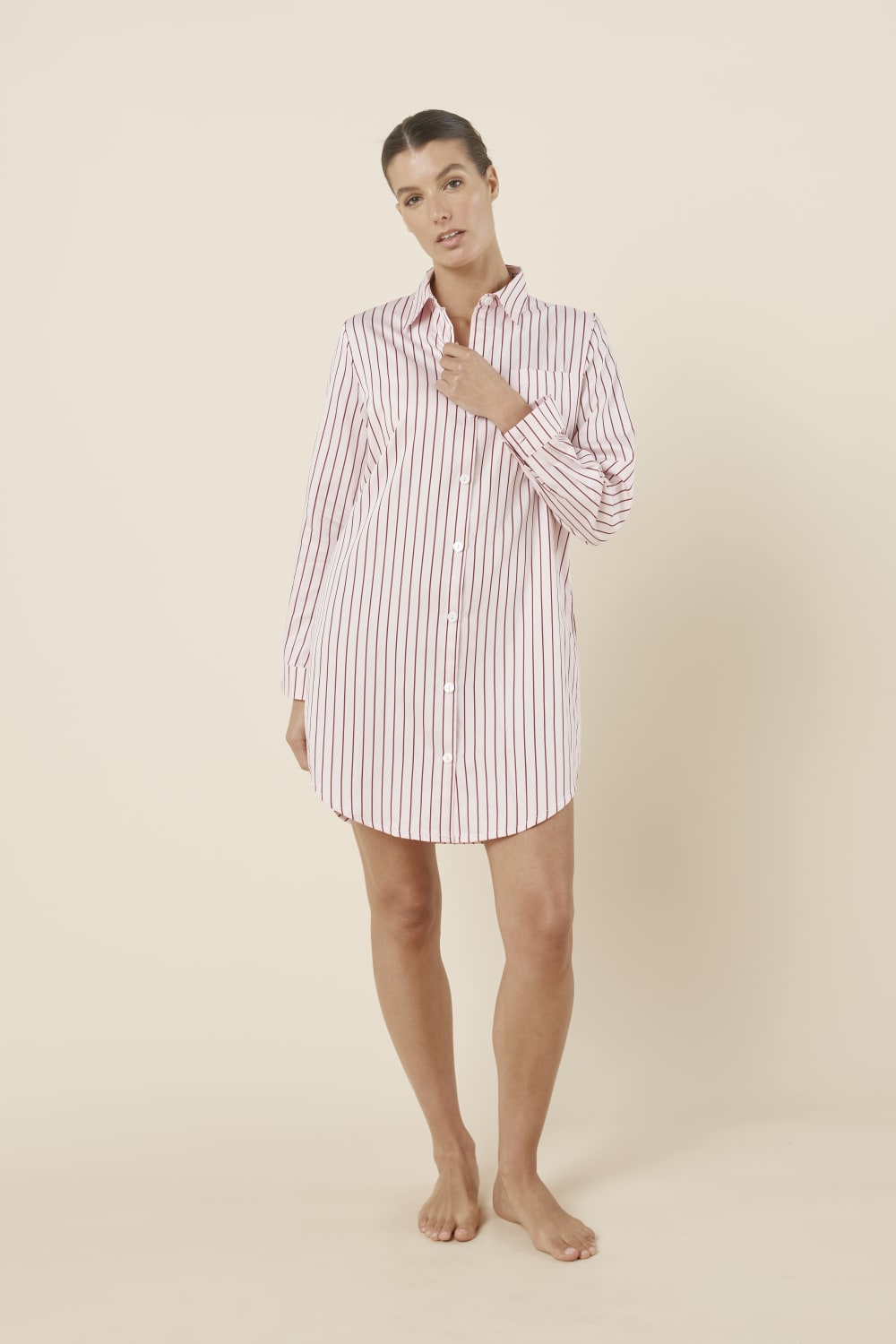 Woman wearing a pink striped Lolita Stripe Night Shirt dress against a beige background front on view