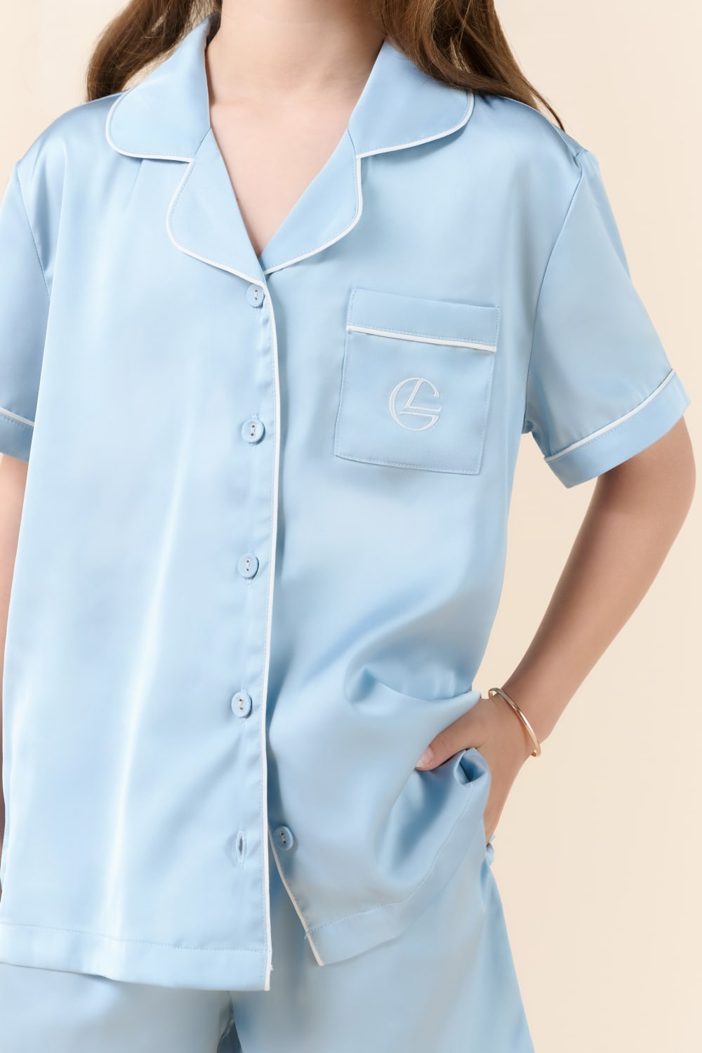 Child in light blue Gingerlilly Sleepwear short-sleeve pajama set with white piping.