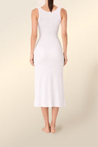 Woman wearing Monique Long Sleeveless Henley Dress Ivory Ecru full length back view showing fitted ribbed midi silhouette