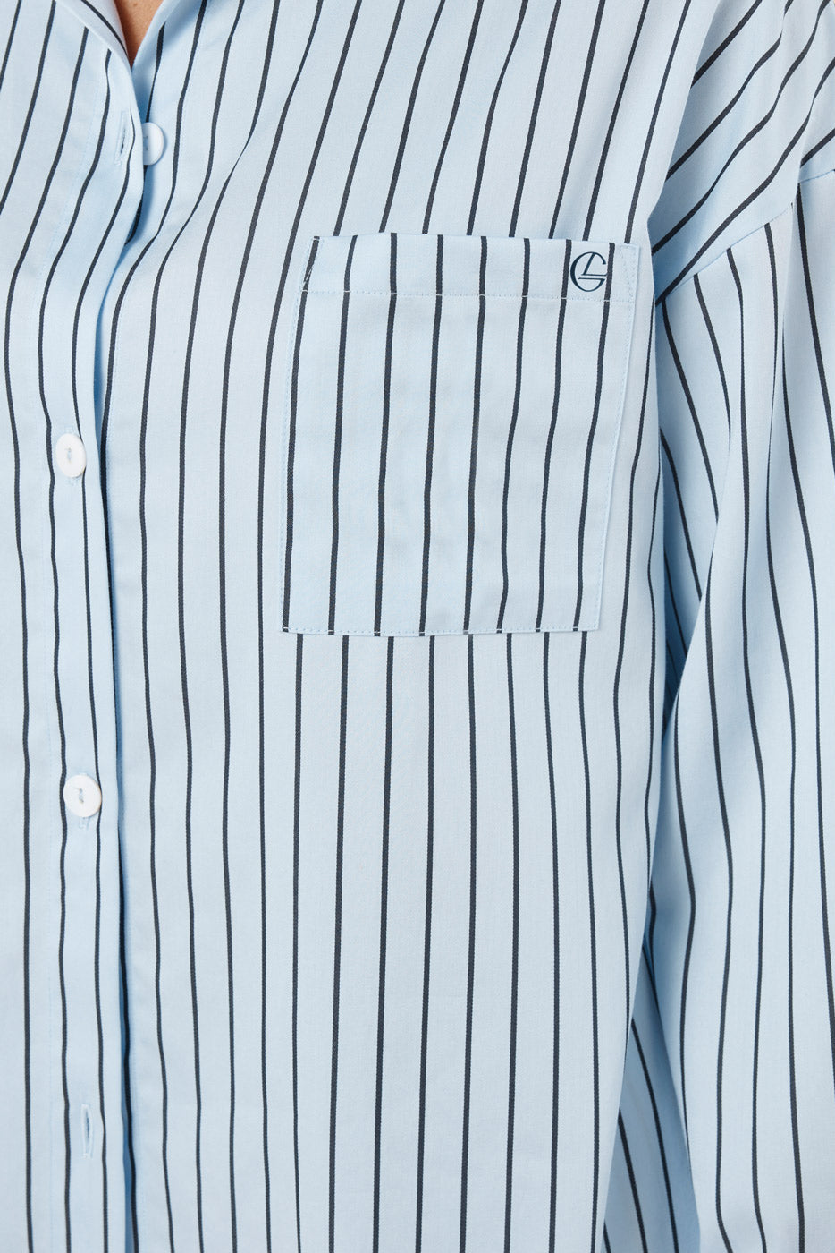 Close-up of a light blue and white striped shirt with a pocket and button details.
