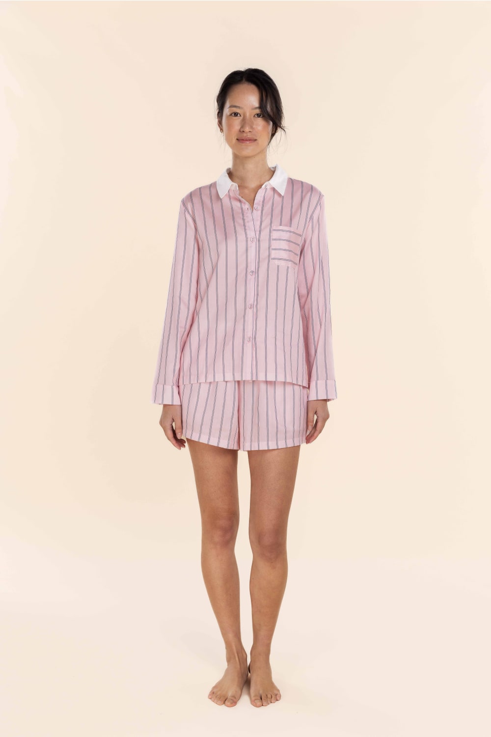 Woman wearing Gingerlilly Sleepwear pink striped cotton pyjama set on light background