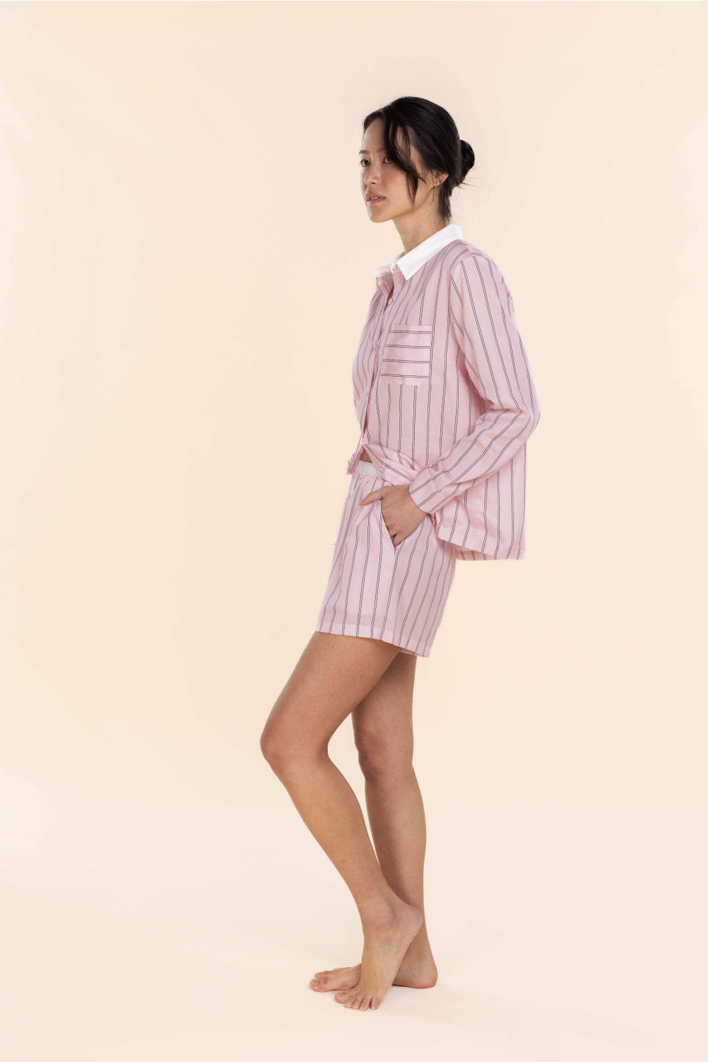 Woman wearing a pink and white striped outfit on a beige background