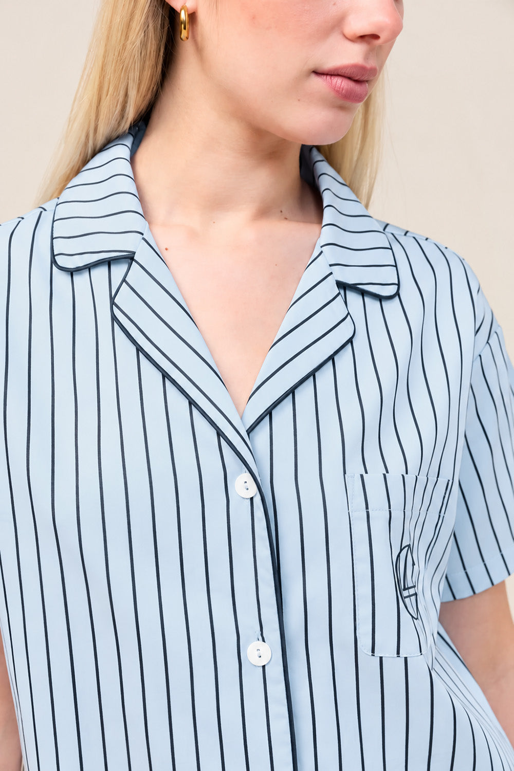 Close-up of the Poppy Stripe Short PJ Set in Blue, showing the collar and embroidered logo