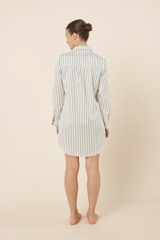 Woman wearing a lolita stripe night shirt in ecru black and ivory white stripe back view on a beige background