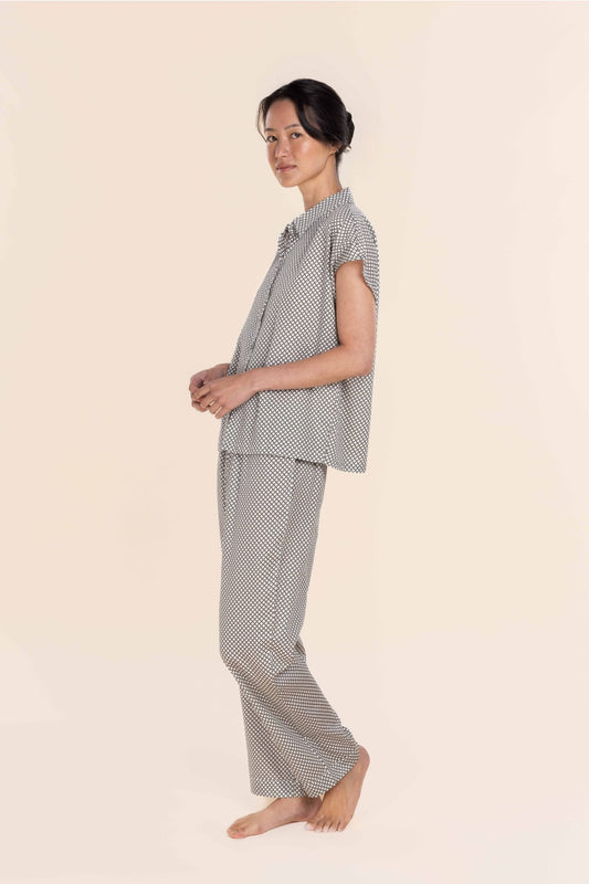 Woman wearing a checkered pajama set on a beige background