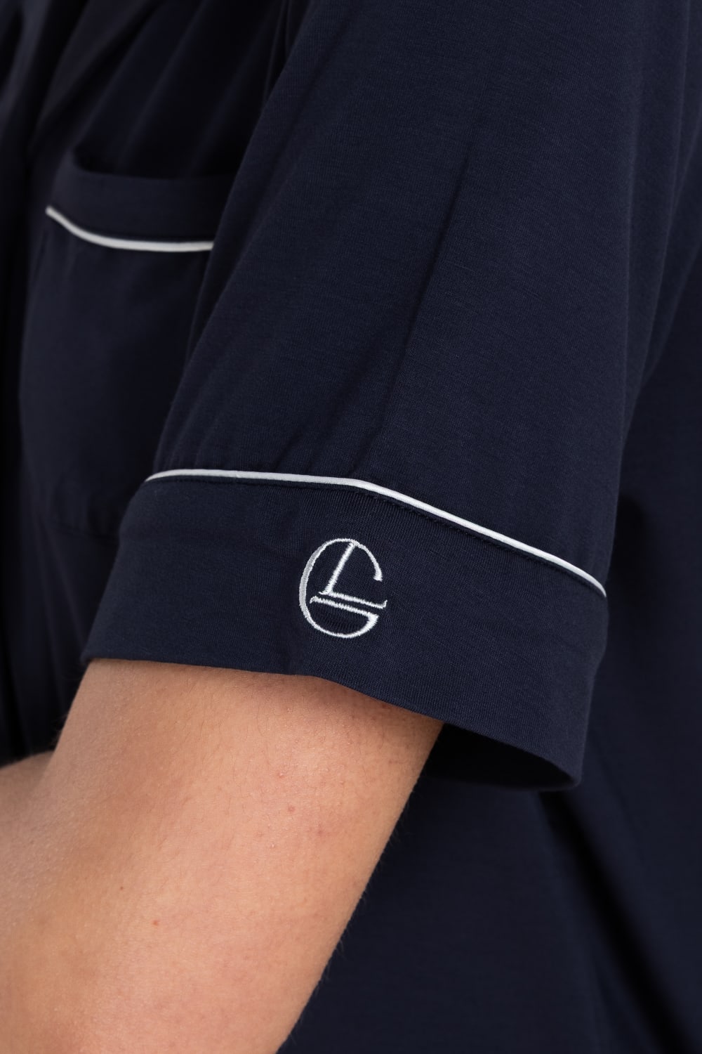 Close-up of the Sadie Bamboo Short PJ Set in Navy, showing the sleeve with white piping and embroidered logo