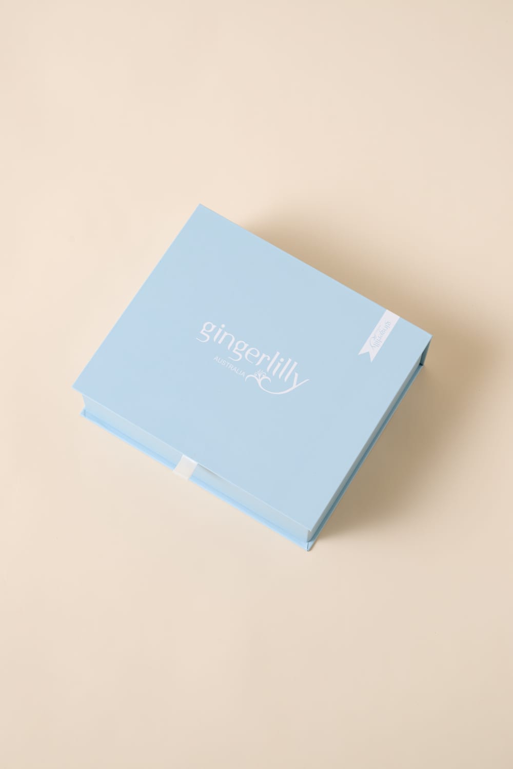 Light blue Gingerlilly Sleepwear gift box with logo on beige background