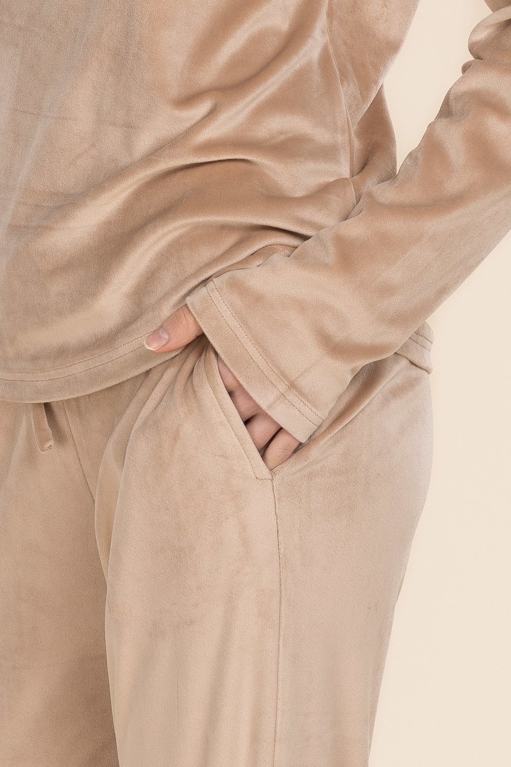 Beige sweatshirt and pants worn by a person, with a neutral background